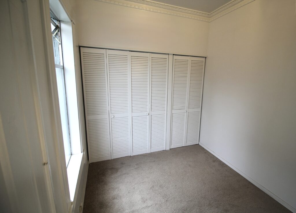 Small empty room with closed closet doors.