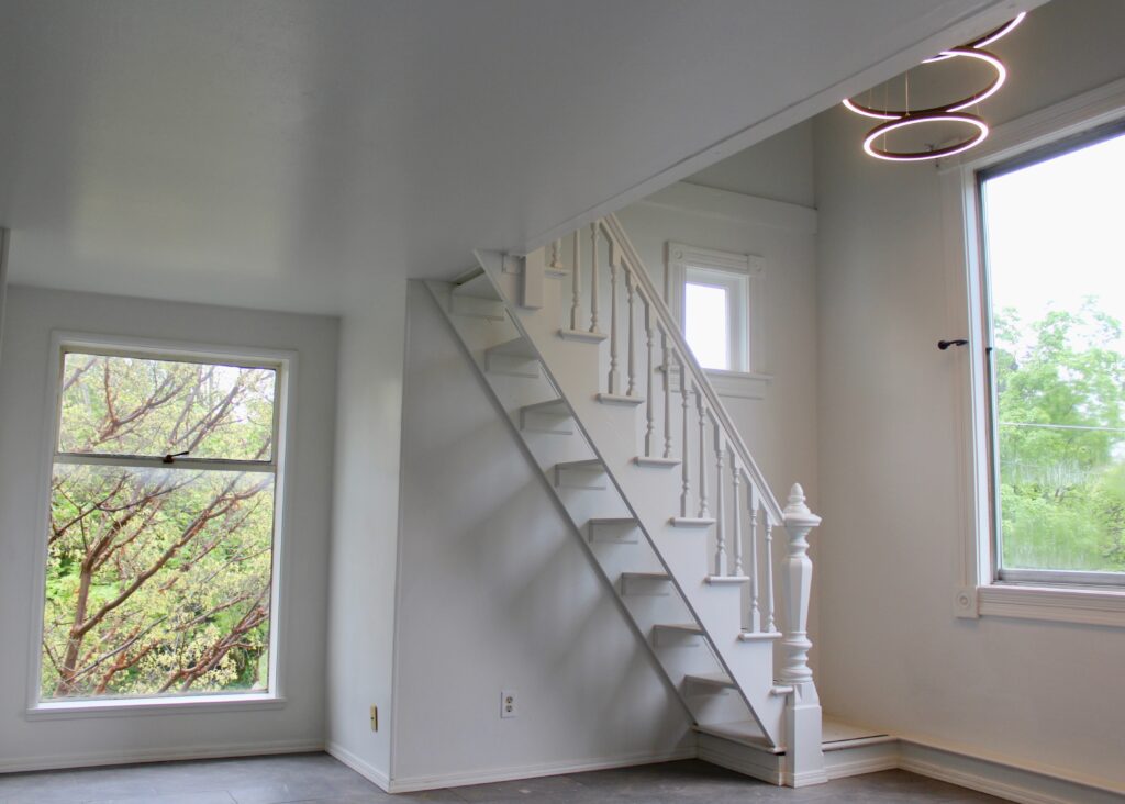 White staircase in modern, bright room interior.