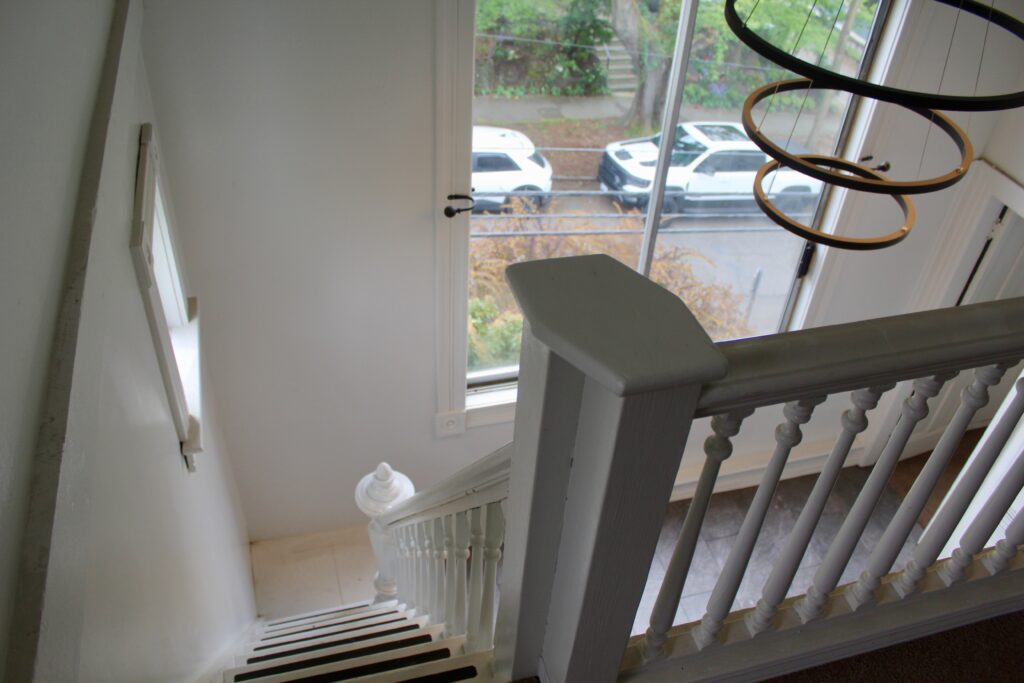 Staircase with window overlooking parked cars.