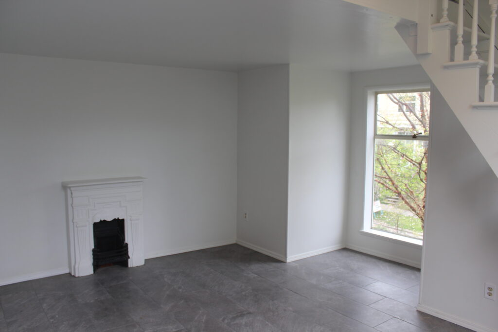 Minimalist room with fireplace and large window.