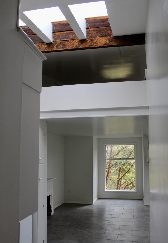 Modern room with skylight and large window.